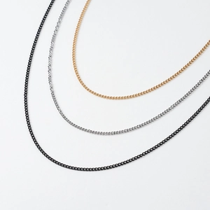 Vue détaillée de colliers à maille gourmette en or, argent et noir avec finition polie