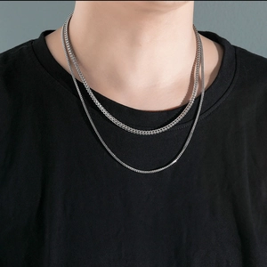 Gros plan d'un collier double épaisseur en acier inoxydable argenté sur un mannequin