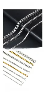 Macro detail of 18K gold plated and silver stainless steel box chains on black leather