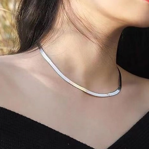 Collier maille serpent plate en acier inoxydable poli porté au cou de style minimaliste
