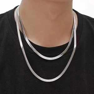 Détail du collier à double chaîne plate en acier inoxydable argenté porté par un mannequin