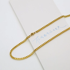 Detailed view of shiny 18K gold plated stainless steel box chain with lobster clasp