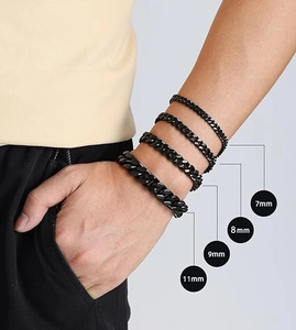 Détail de quatre largeurs de gourmettes noires en acier inoxydable portées au poignet