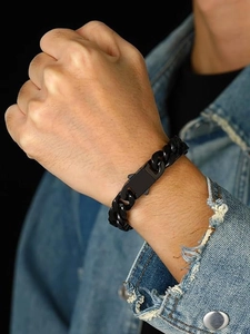 Détail de la gourmette noire mate avec boucle carrée robuste sur le poignet