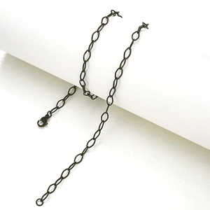 Detail of matte black oval link stainless steel chain necklace with lobster clasp