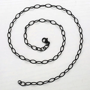 Detail of matte black stainless steel chain link with classic lobster clasp closure