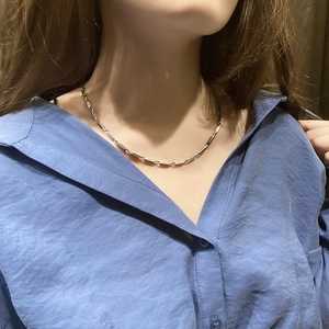 Collana a maglie cilindriche in acciaio inossidabile lucido indossata sul collo