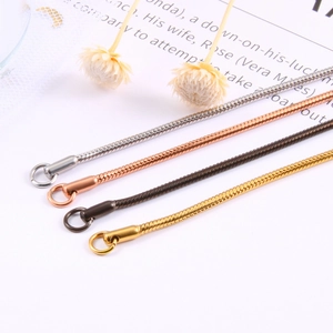 Dettaglio di catene a serpente multicolore in acciaio inossidabile con finitura oro 18K
