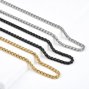 Détail de chaînes en maille tressée en argent, noir et or avec texture tissée