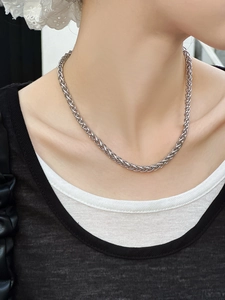 Collier chaîne maille épi en acier inoxydable argenté porté par un mannequin femme