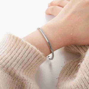 Bracelet chaîne serpent en acier inoxydable argenté poli porté sur un poignet féminin