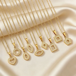 Golden geometric heart and round necklaces with sparkling zircons on champagne satin cloth