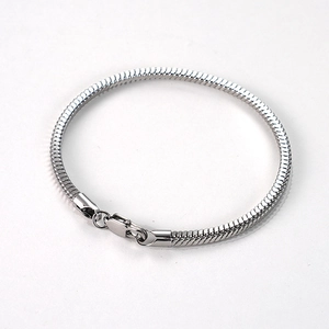 Détail d'un bracelet en maille serpent argentée en acier inoxydable avec fermoir mousqueton