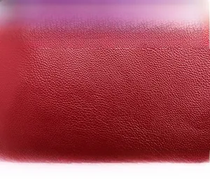 Close-up of luxury red lychee pattern leather texture on a stylish crossbody bag