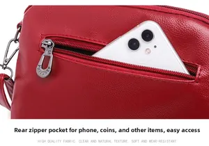 Detail of red leather crossbody bag with litchi texture and functional back zipper pocket