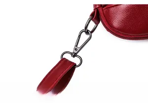 Close-up of wine red litchi grain leather texture and metallic strap hook on women's bag