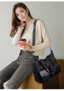 Detailed view of black nylon shoulder bag with multi-pocket design and silver metal buckle