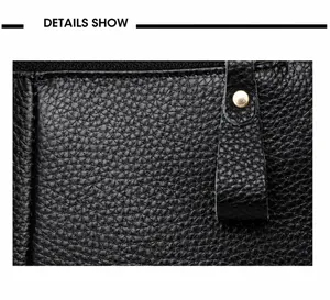 Close-up of black lychee grain genuine leather bag with gold hardware and fine texture