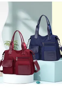 Detailed view of nylon tote bag storage compartments with leather trim and front pockets