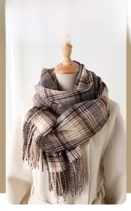 Détail d'une écharpe d'hiver à carreaux avec franges présentée sur un mannequin