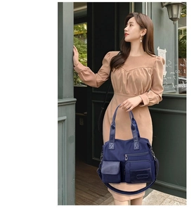 Detail of navy blue nylon tote bag with functional multi-pockets and shoulder strap