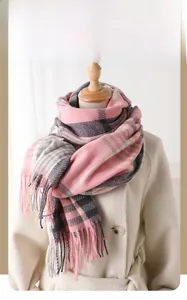Detail of pink and grey plaid winter scarf with fringe on a wool coat