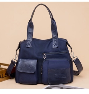 Detail of dark blue nylon tote bag with functional multi-pockets and leather trim finish