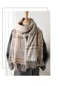 Detail shot of khaki and grey checkered cashmere-like scarf with fringe on a mannequin