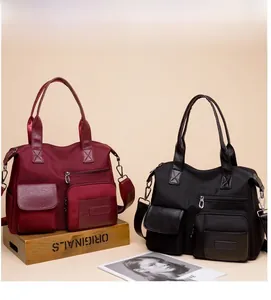 Detailed macro view of dual-color nylon tote bags with multi-pocket design and silver hardware
