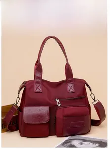 Detail of burgundy nylon tote bag with multiple pockets and adjustable strap