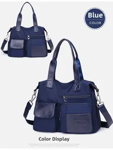 Close-up of blue nylon tote with multi-zipper pockets and leather handles
