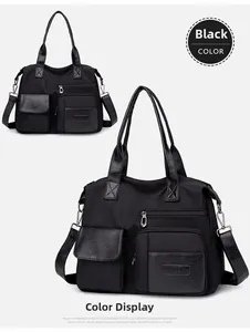 Detail of multi-pocket black nylon tote bag featuring leather texture zippers and straps