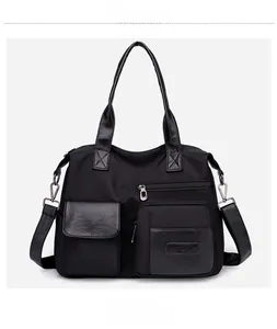 Detail view of the black nylon tote bag with multi-pocket texture and silver hardware