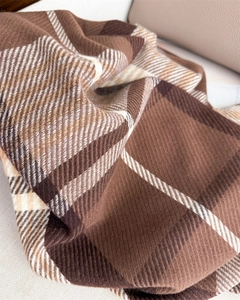 Close-up of classic brown plaid scarf with soft twill weave texture and warm material