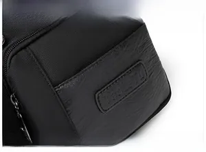 Close-up of black nylon shoulder bag featuring the TanleTu logo and premium hardware zipper
