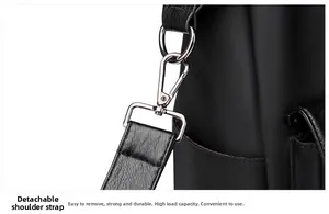 Detail of the detachable shoulder strap with metal lobster clasp on the black nylon tote