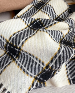 Gros plan sur l'écharpe à carreaux façon cachemire avec des motifs classiques jaune et gris