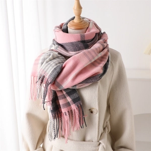 Detail of pink and grey plaid scarf with long fringe on a mannequin with coat