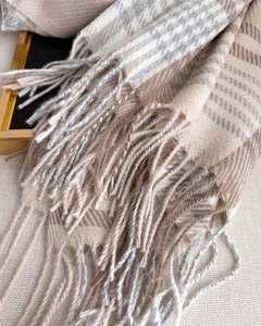 Close-up of houndstooth plaid scarf texture with soft fringe and knit details