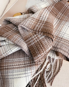 Vue détaillée de l'écharpe à carreaux marron et beige avec des bords à franges classiques