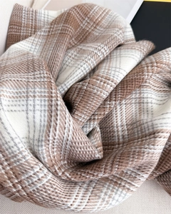 Gros plan d'une écharpe à carreaux et franges avec texture cachemire et tons bruns