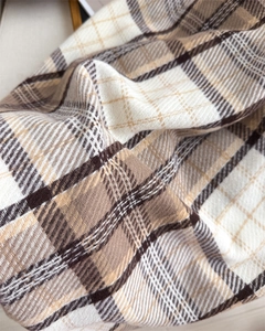 Detailed close-up of brown and beige plaid cashmere scarf showing soft texture and weave