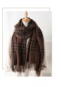 Close-up of brown houndstooth tassel scarf styled on a beige cashmere winter coat
