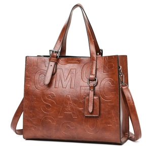 Sac cabas vintage marron avec lettres embossées, poignées et bandoulière réglable