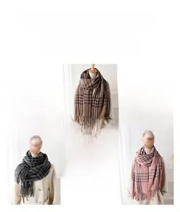 Detail of soft houndstooth cashmere feel scarf with fringe in brown, grey, and pink
