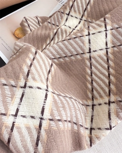Gros plan sur l'écharpe classique à carreaux marron avec tissage sergé et texture cachemire