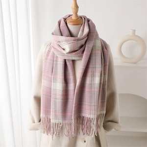 Écharpe à carreaux rose et blanc avec franges sur mannequin dans un décor chaleureux