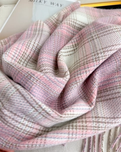 Détail d'une écharpe à carreaux rose et violet avec des finitions à franges douces
