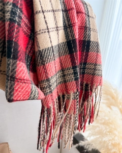 Detail of red and beige checkered scarf showing soft texture and fringe tassels