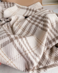 Detail of houndstooth scarf showing soft knit texture and subtle gold metallic threads